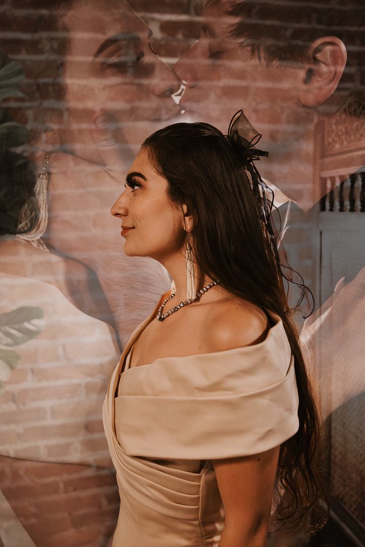 A woman in an elegant off-shoulder cream dress poses against a rustic brick wall in a series of profile shots.