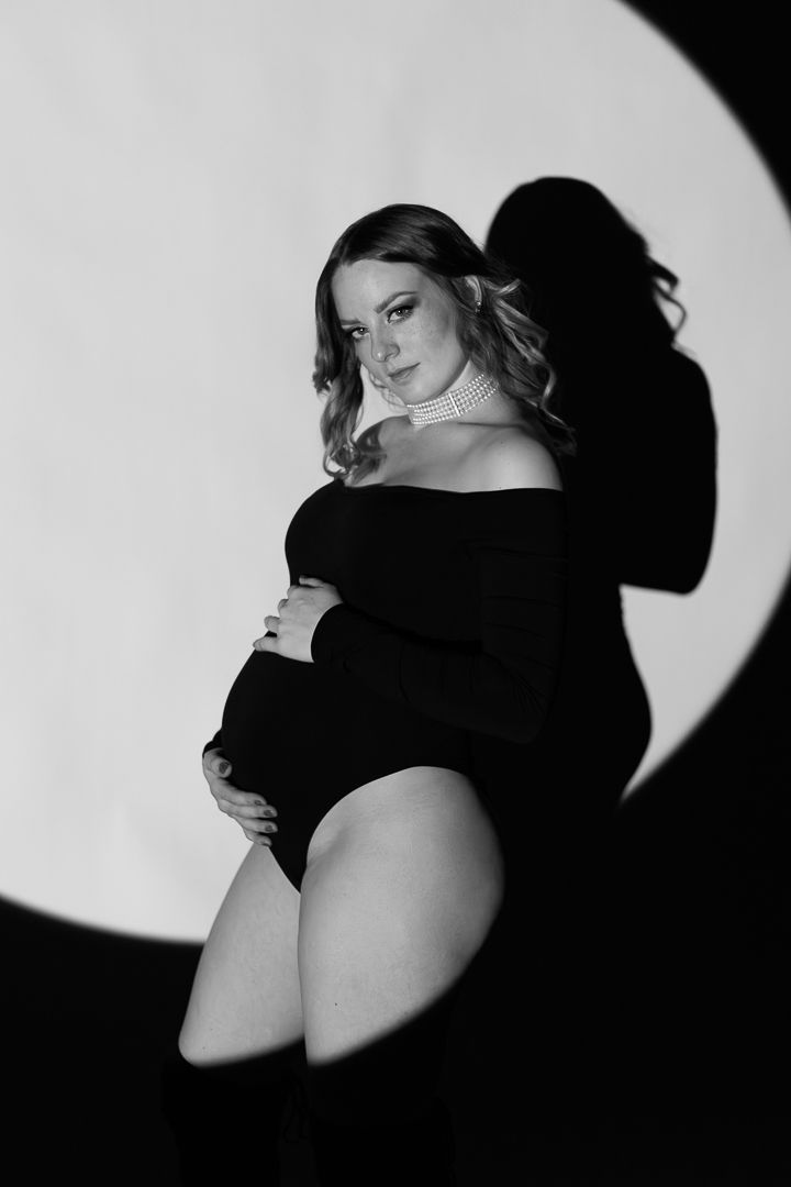 Dramatic black and white artistic portrait with side view silhouettes showing different angles against a dark background.