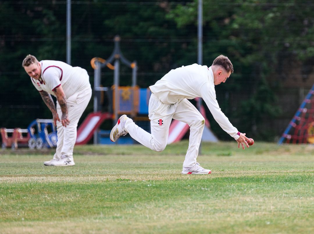 Cricket bowler delivers the ball during a competitive grassroots cricket match
