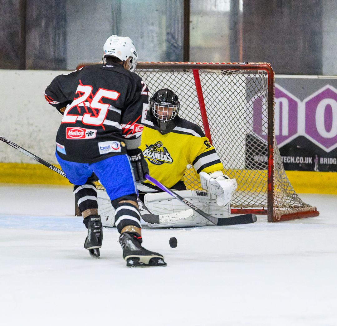 ce hockey forward attacks the goal as the goalkeeper prepares to make a crucial save.