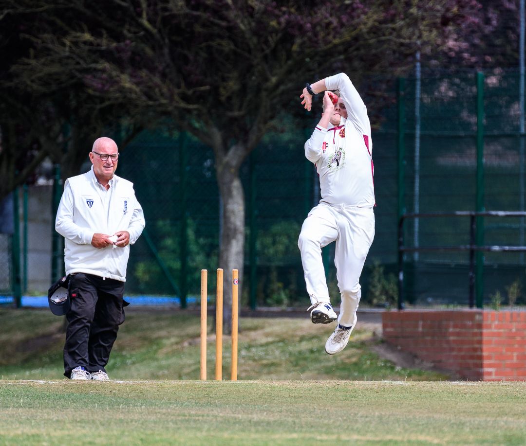 Cricket bowler delivers the ball during a competitive grassroots cricket match