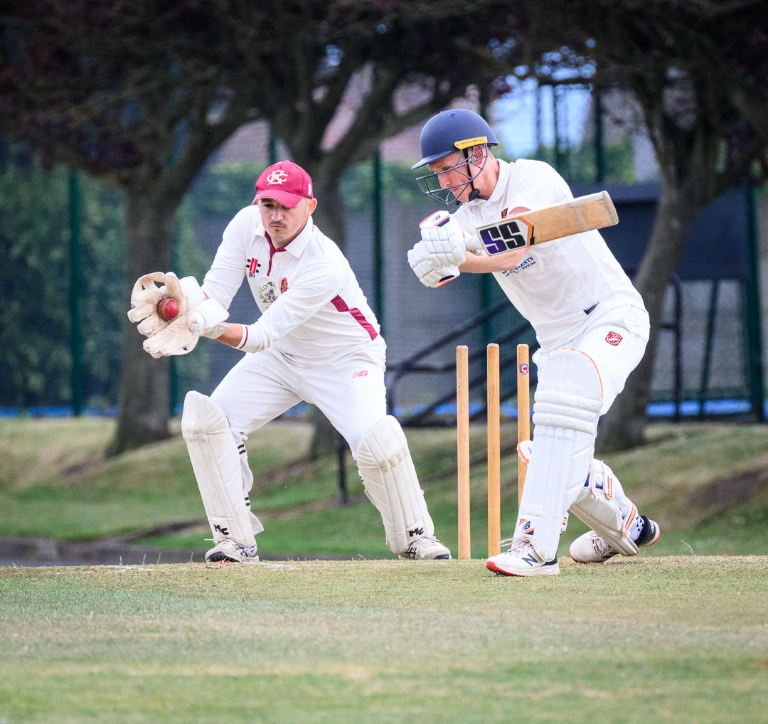 Cricket bowler celebrates after taking a wicket during a competitive grassroots cricket match.