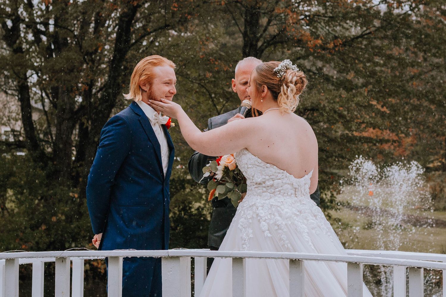 Bride lovingly holds grooms face while he cries upon seeing her walk down the aisle