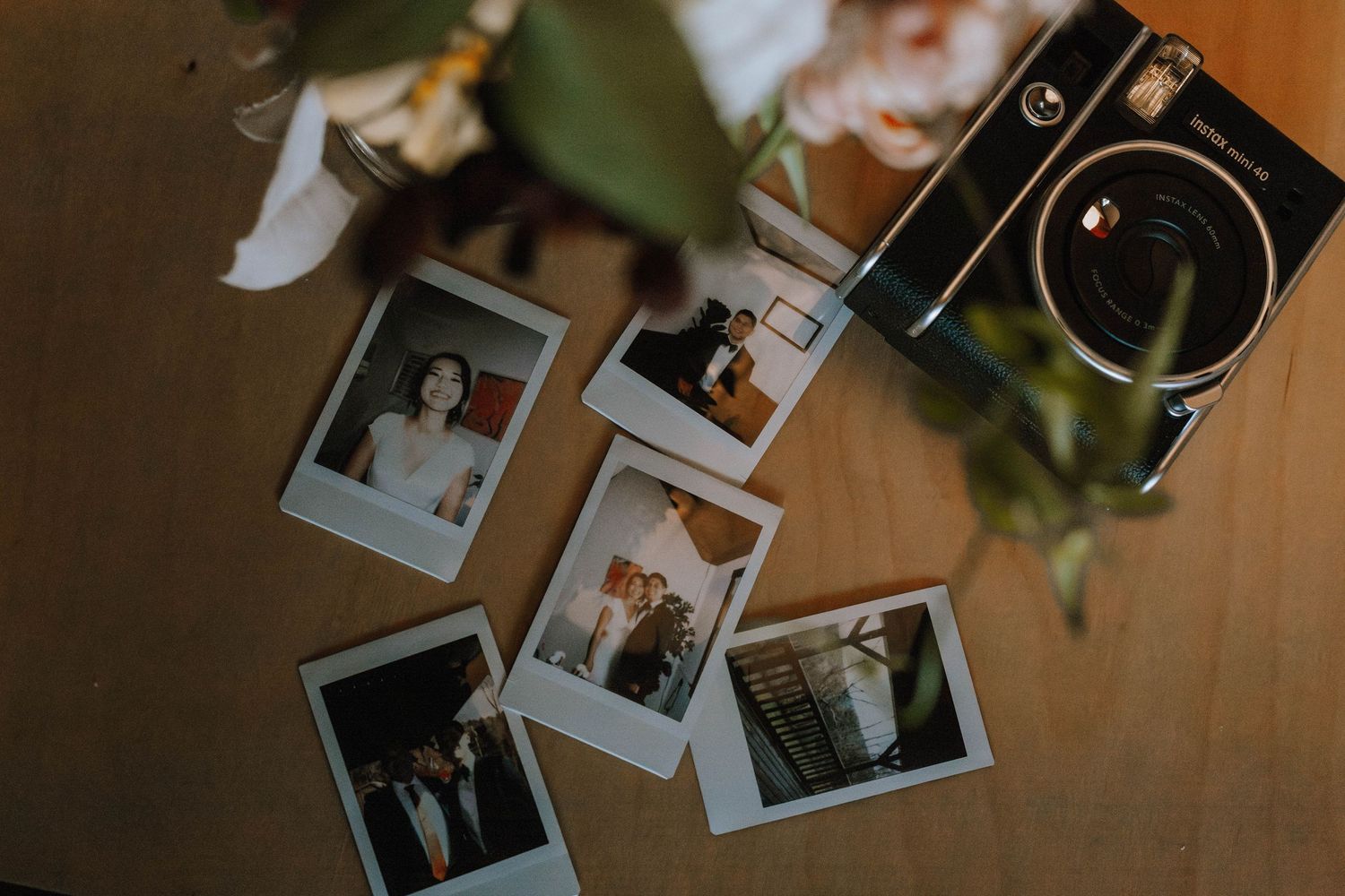 Polaroids of Bride and Groom laid out on a tabled next to the Polaroid camera