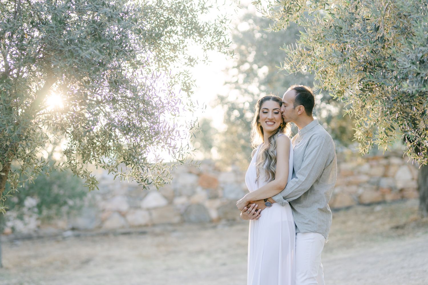 Couple embracing in Athens at golden hour, romantic editorial portrait in soft natural light.