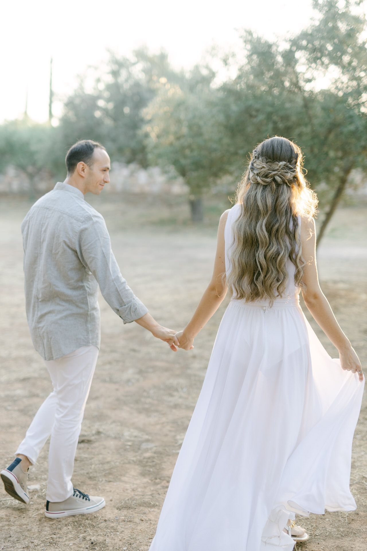 Couple walking hand in hand during an Athens lifestyle photoshoot, captured in warm golden light.
