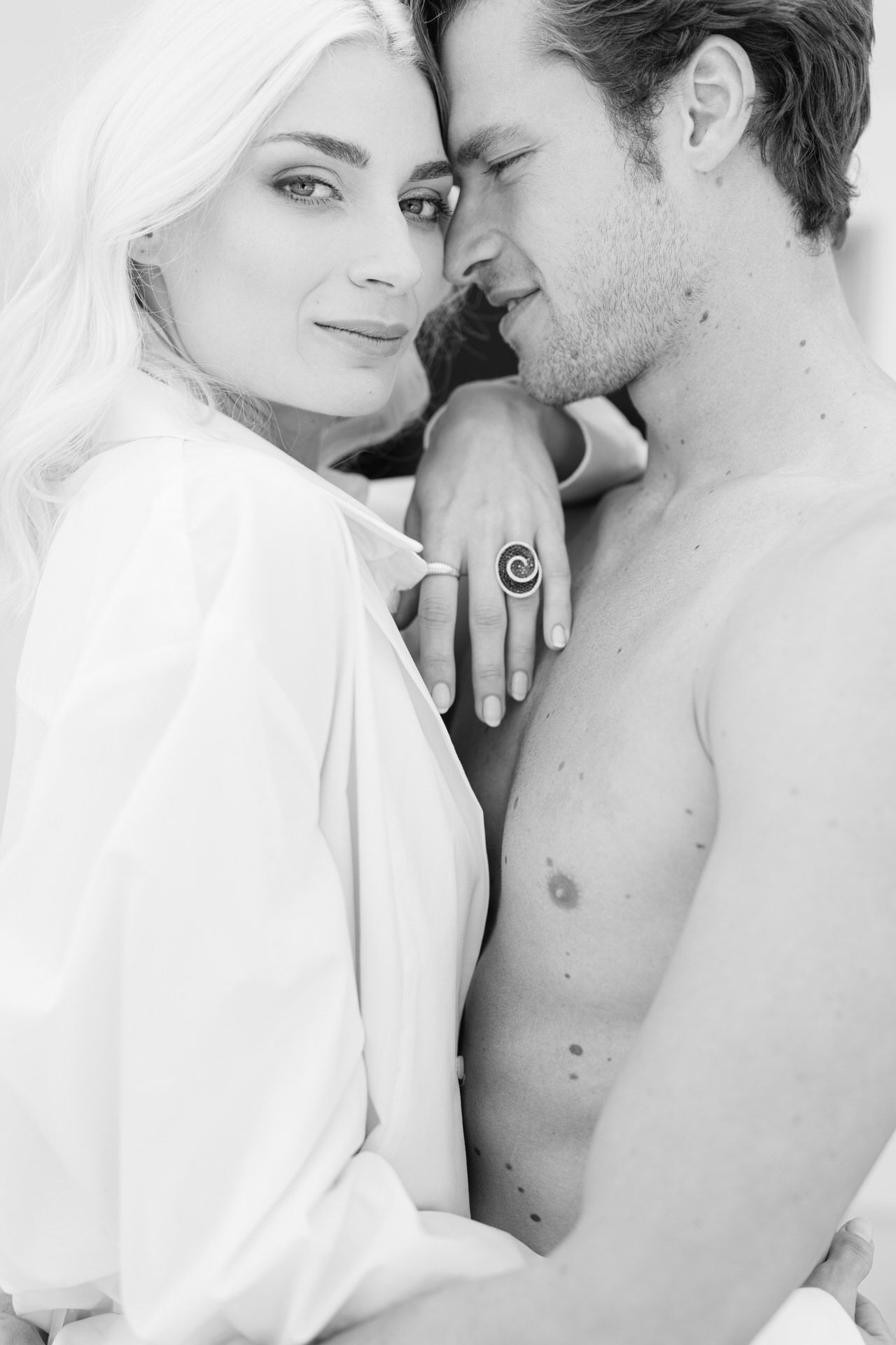 Private couple lifestyle session indoors in Athens, soft window light and intimate connection.