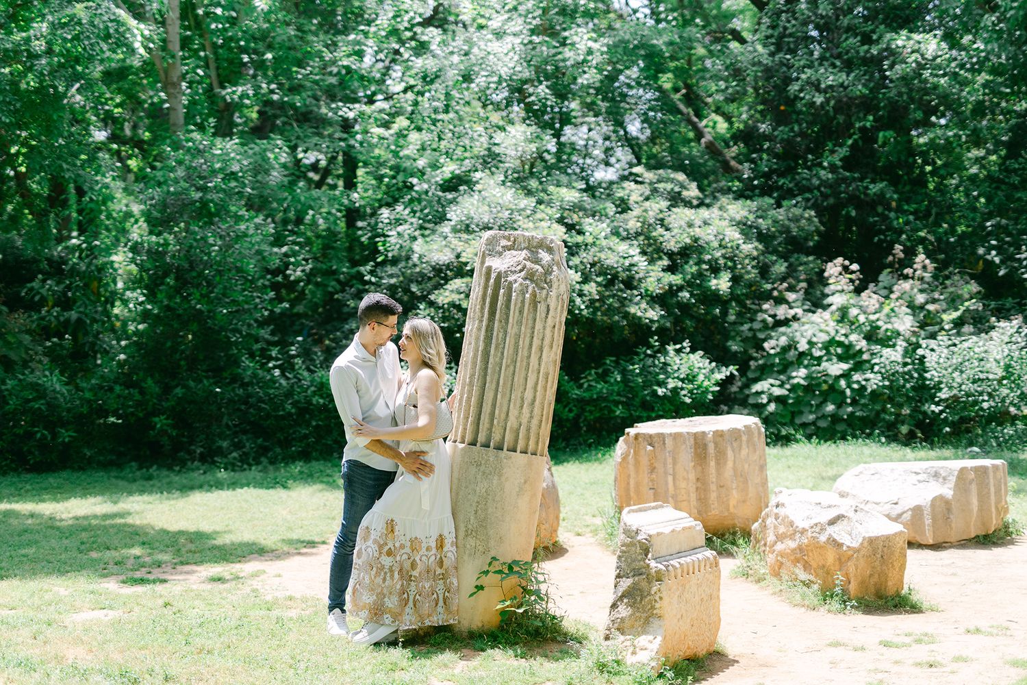 Couple portrait on Athens marble pillars, romantic editorial framing in natural light.