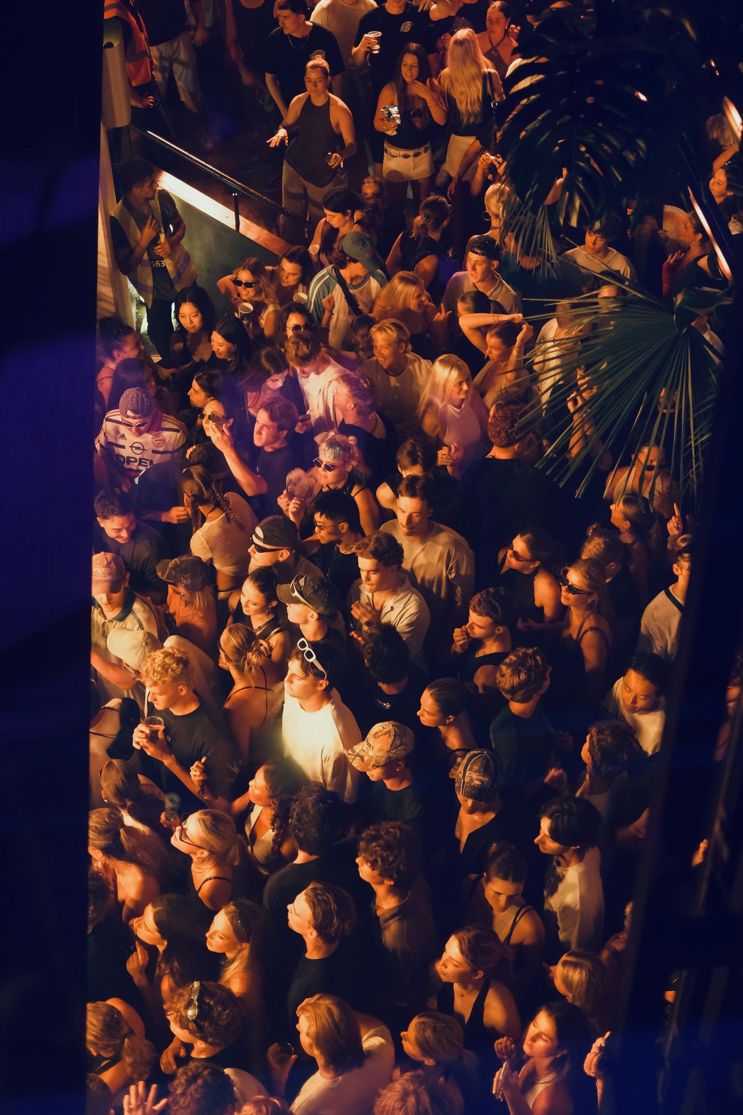 Aerial view of a dense crowd of people gathered at an indoor nightclub music event.