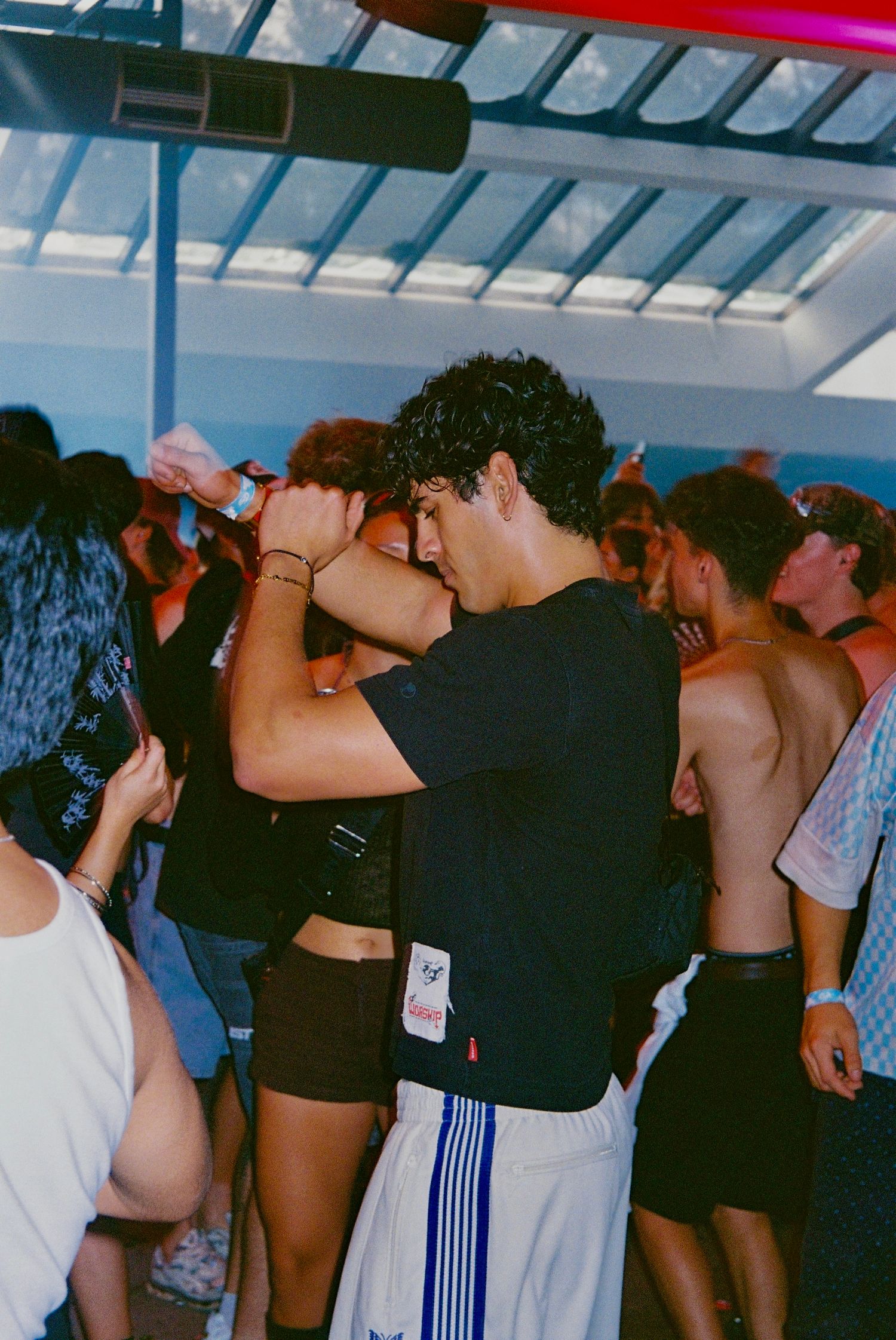 Young couple embracing and dancing in crowded indoor party venue.