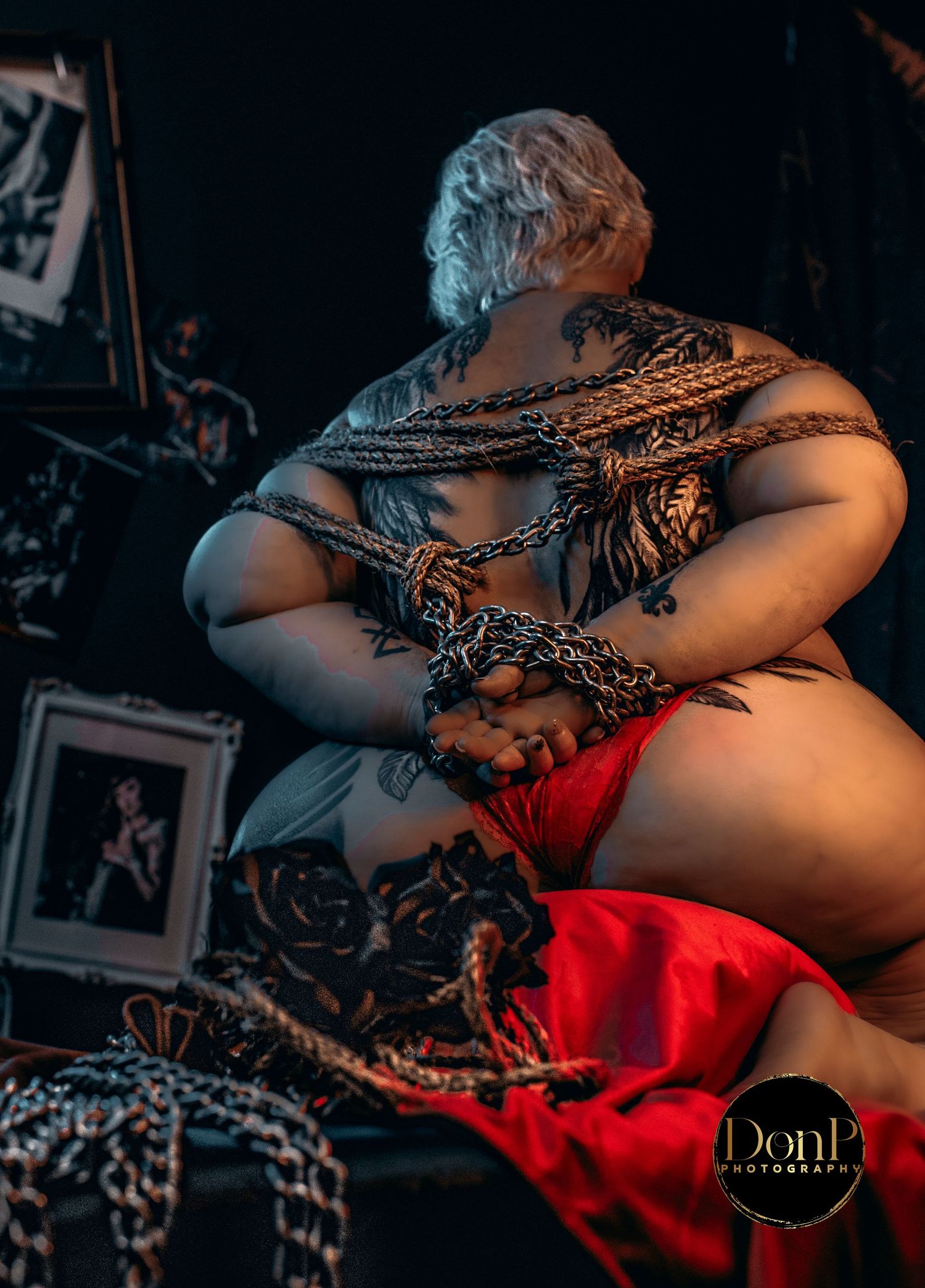 Studio portrait of a seated subject with layered styling and symbolic elements, emphasizing presence, storytelling, and form.