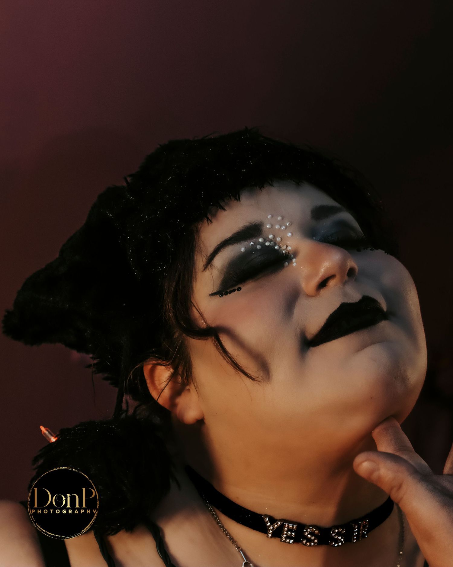 Close-up portrait with theatrical makeup and soft lighting, blending fantasy and alternative identity boudoir