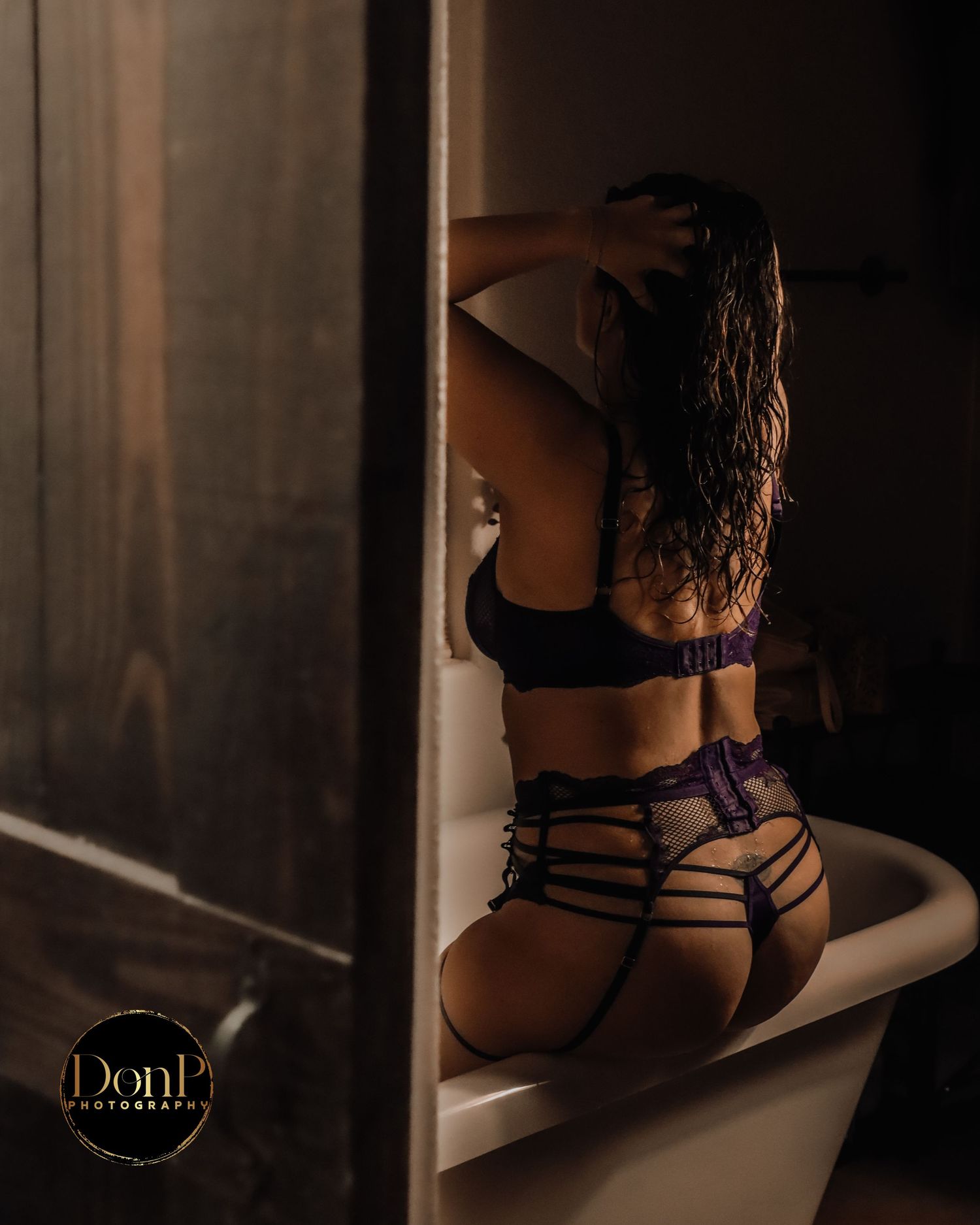 Moody portrait of a seated figure in window light, emphasizing silhouette, styling, and reflective calm.