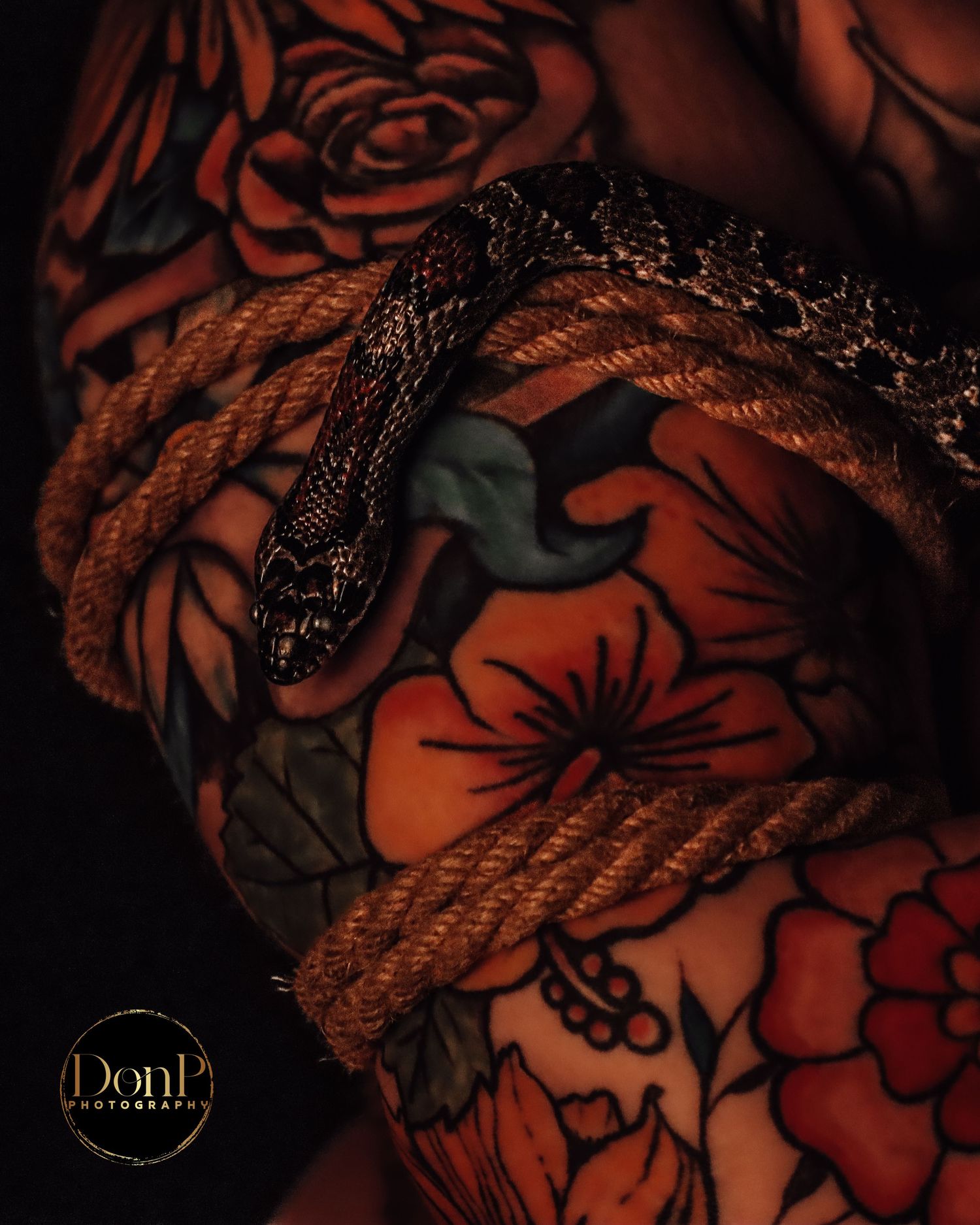Artistic close-up portrait featuring rope, tattooed skin, and a snake motif, symbolizing transformation, power, and trust. boudoir