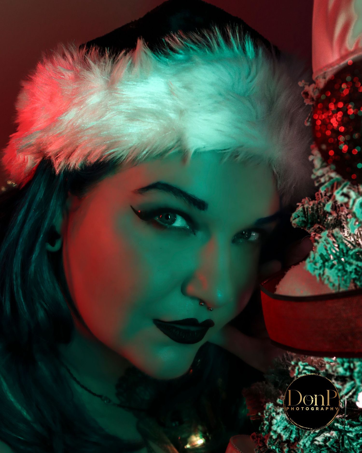 Seasonal boudoir photography close-up with festive styling and colored light, emphasizing expression, texture, and holiday atmosphere.