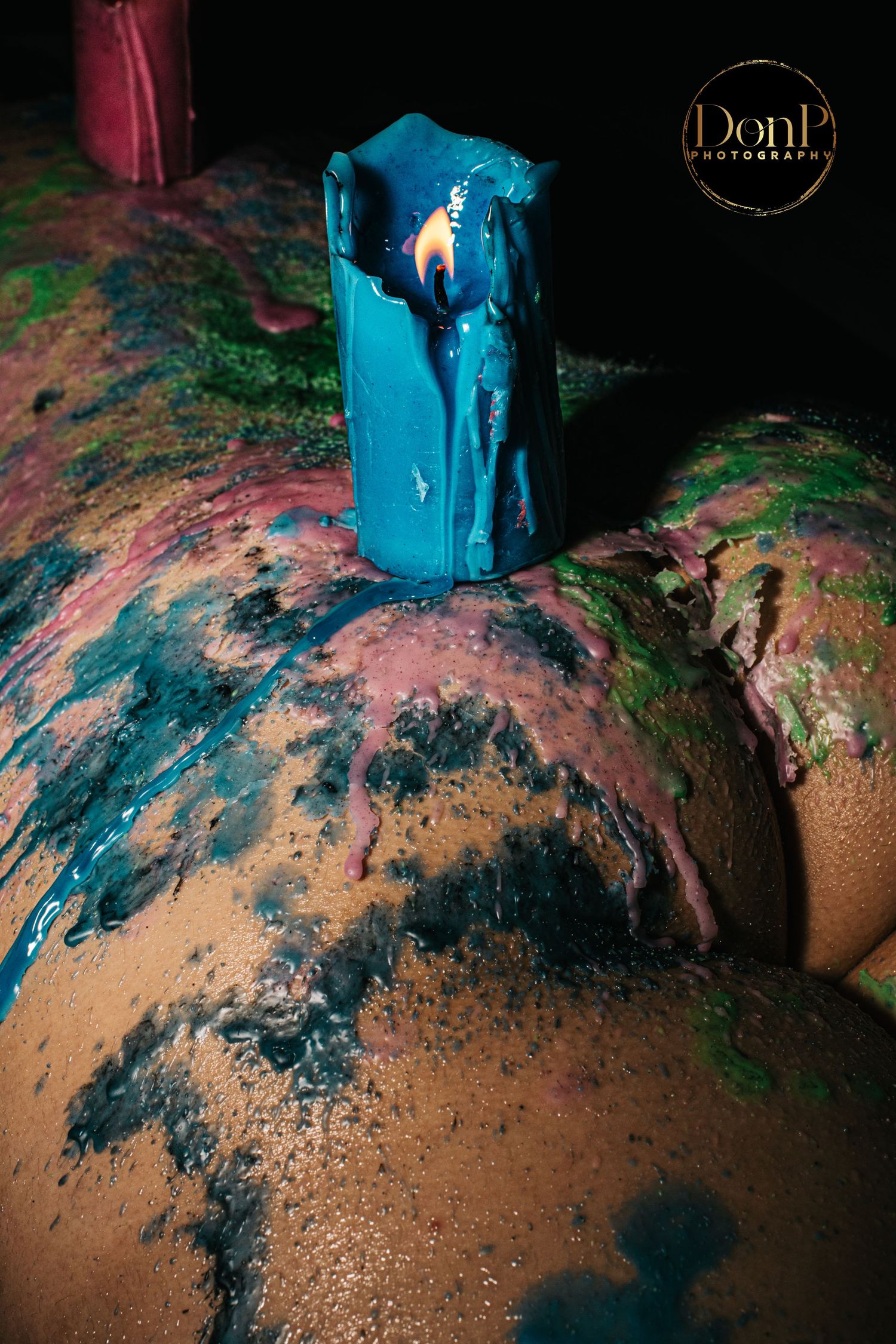 Close-up of warm wax dripped across skin under dramatic lighting, capturing sensory play, texture, and intimate atmosphere boudoir