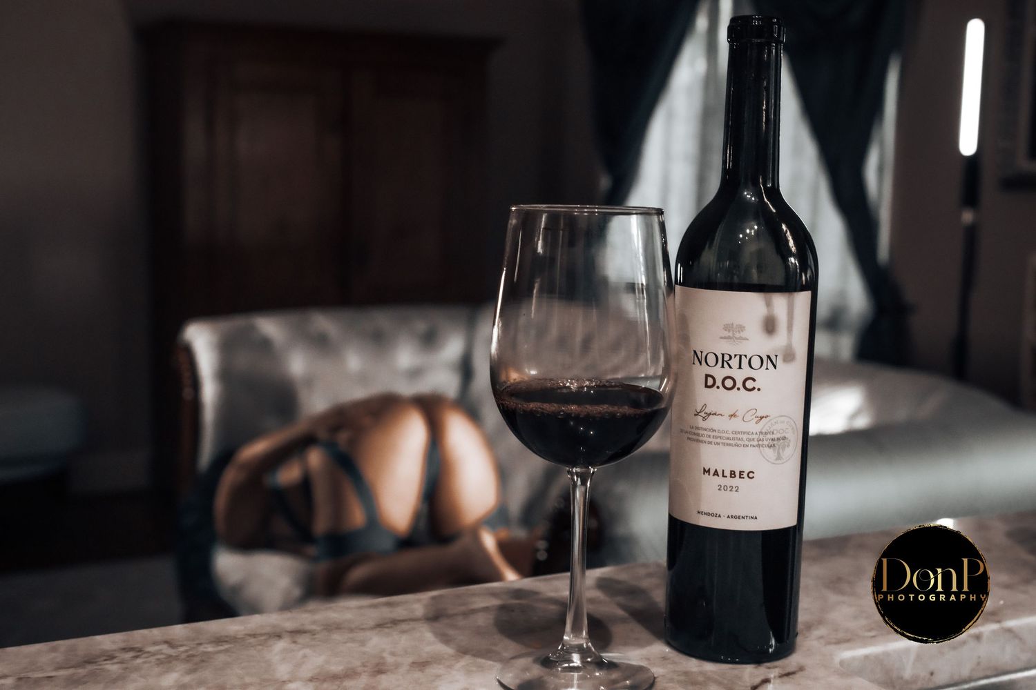 Cinematic still life of wine and shadowed livingroom, suggesting intimacy, ritual, and quiet connection. boudoir