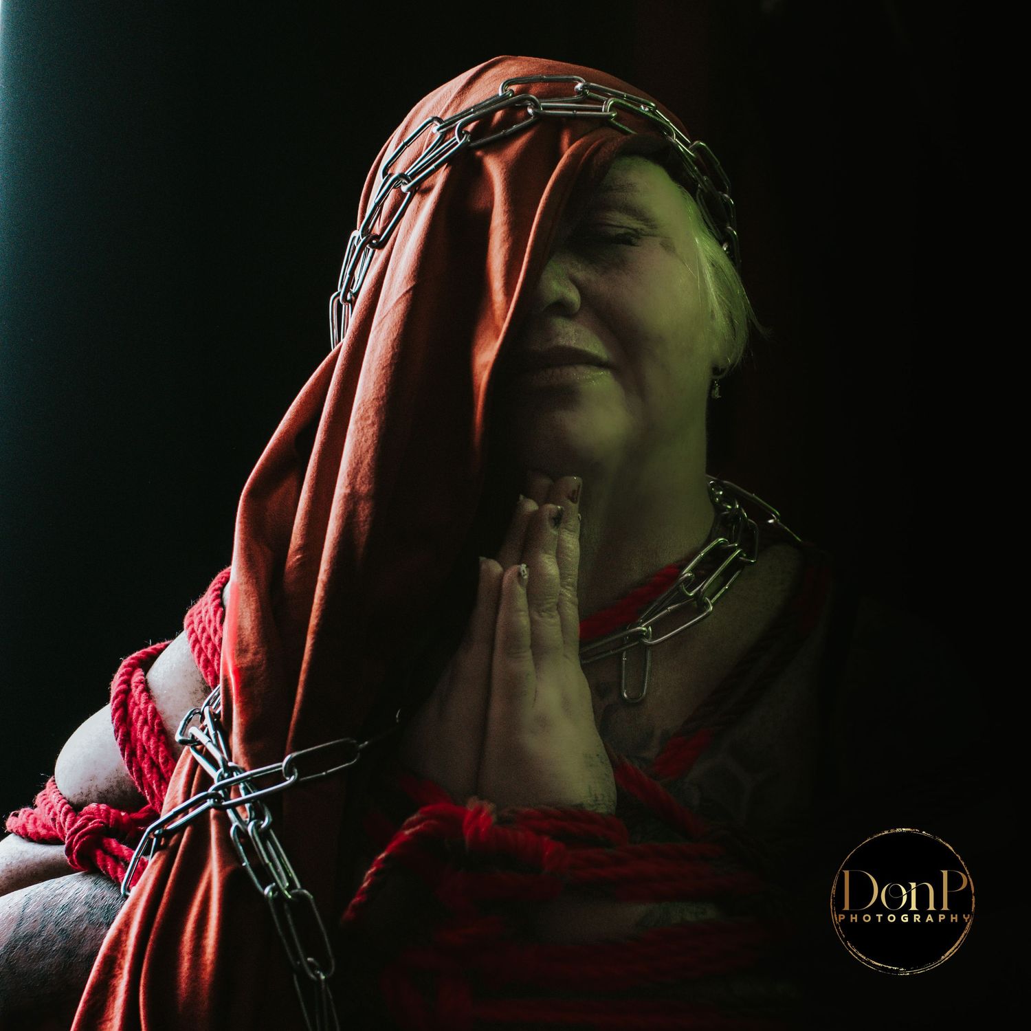Moody portrait of a veiled subject in soft green light, blending shadow, texture, and quiet emotional depth.