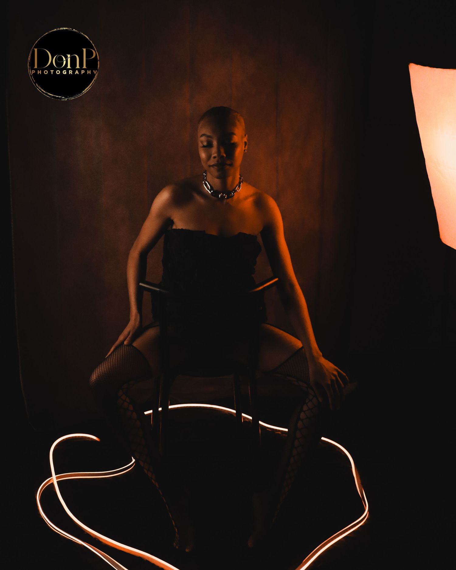Conceptual boudoir photography portrait blending warm light and symbolic styling to emphasize presence and form.