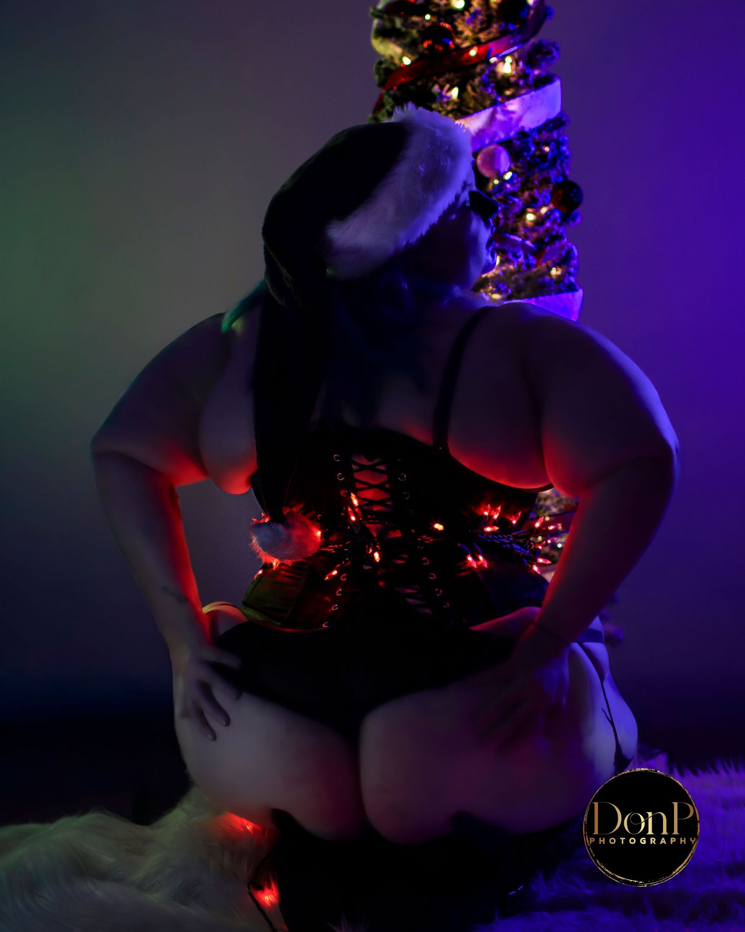 Low-light holiday portrait with string lights, sensual kink-adjacent boudoir mood, body-positive lifestyle photography. boudoir