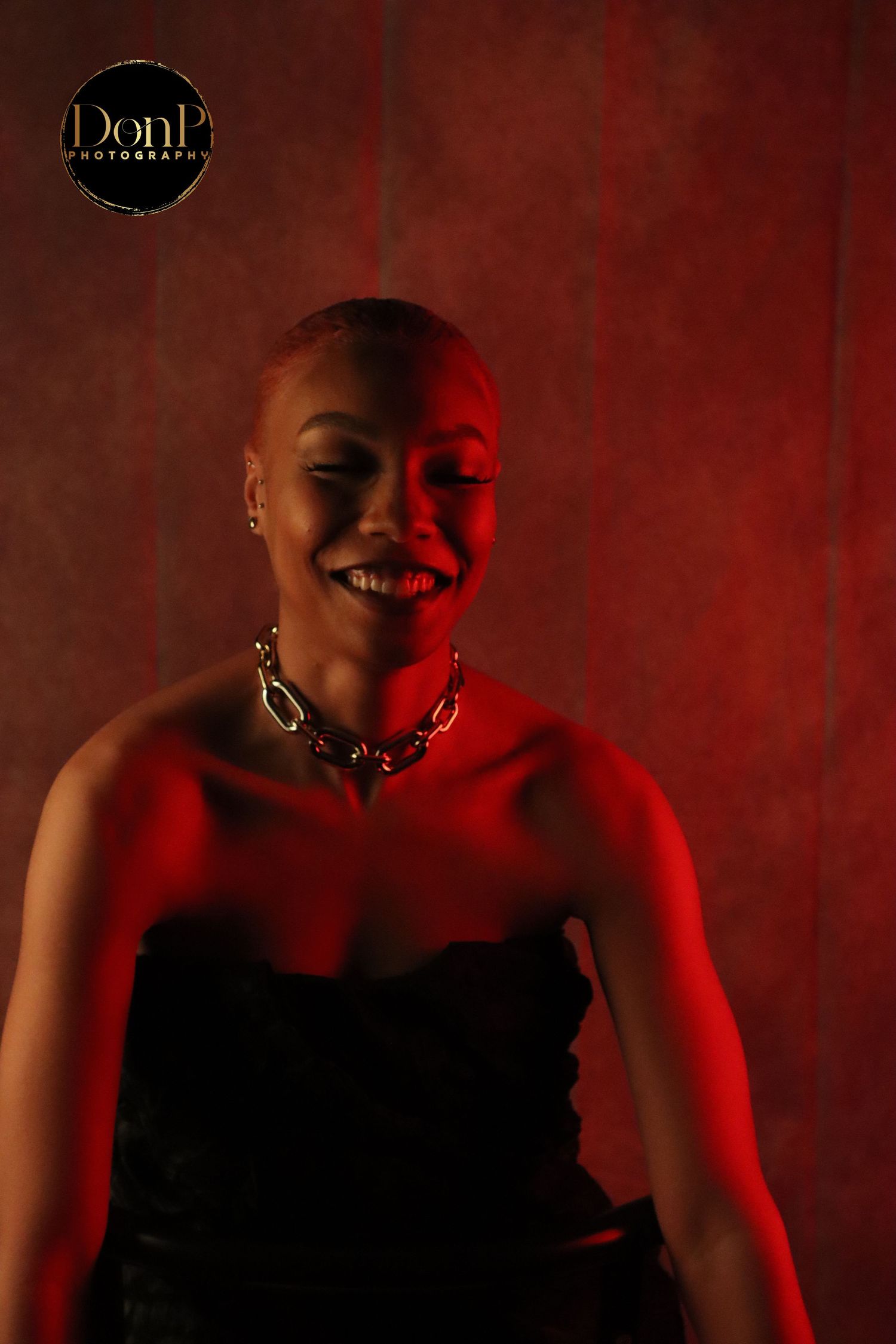 Expressive boudoir photography portrait in red lighting, capturing movement, emotion, and bold visual contrast.