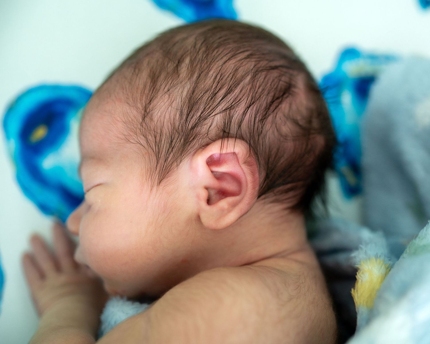 Close-up profile view of a sleeping newborn baby with delicate features.