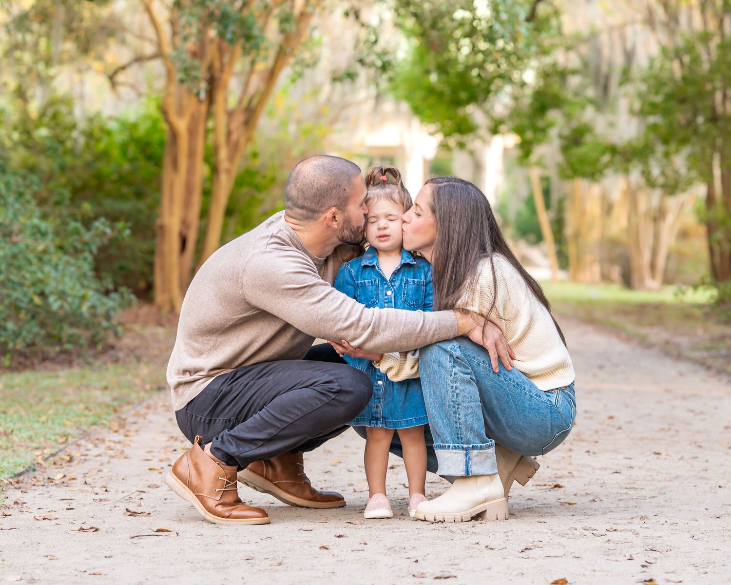 Candid family interactions captured on a natural path surrounded by trees and fallen leaves.