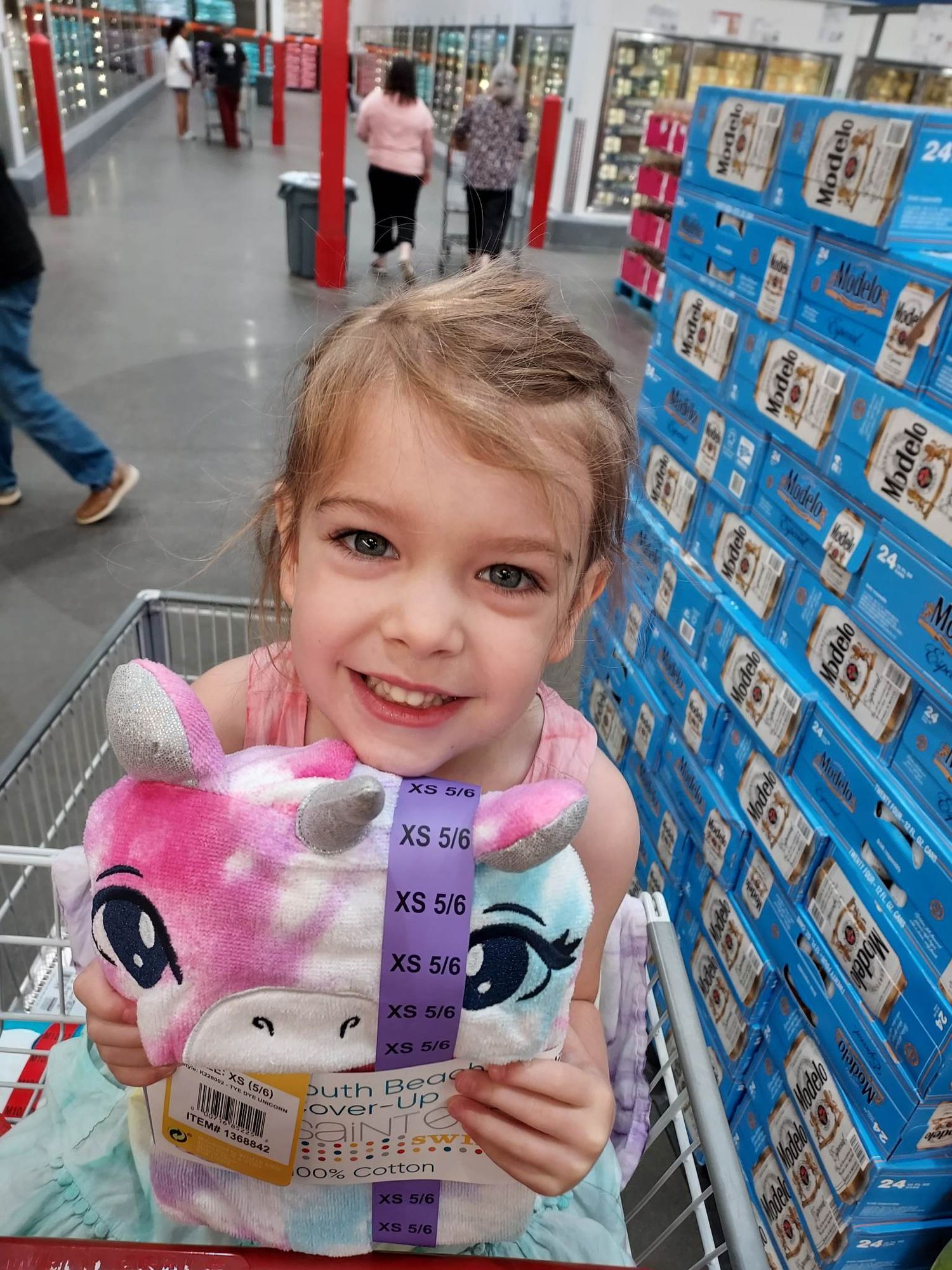 Three year old Jenny smiles with a toy with photo taken from above