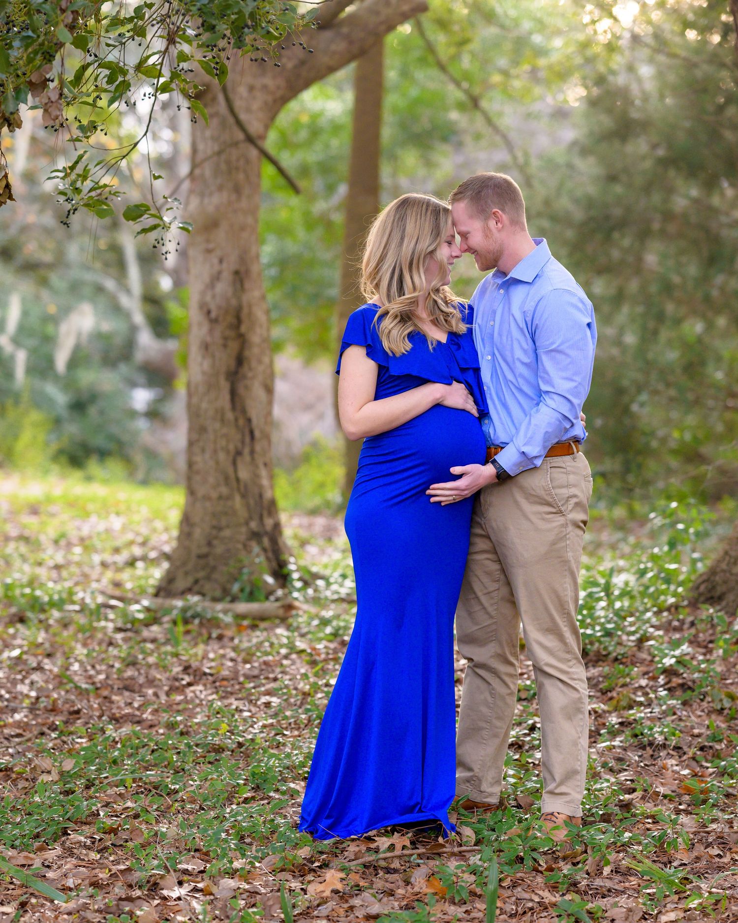 Nicole and her husband stand facing each other during their maternity session at Hampton Park