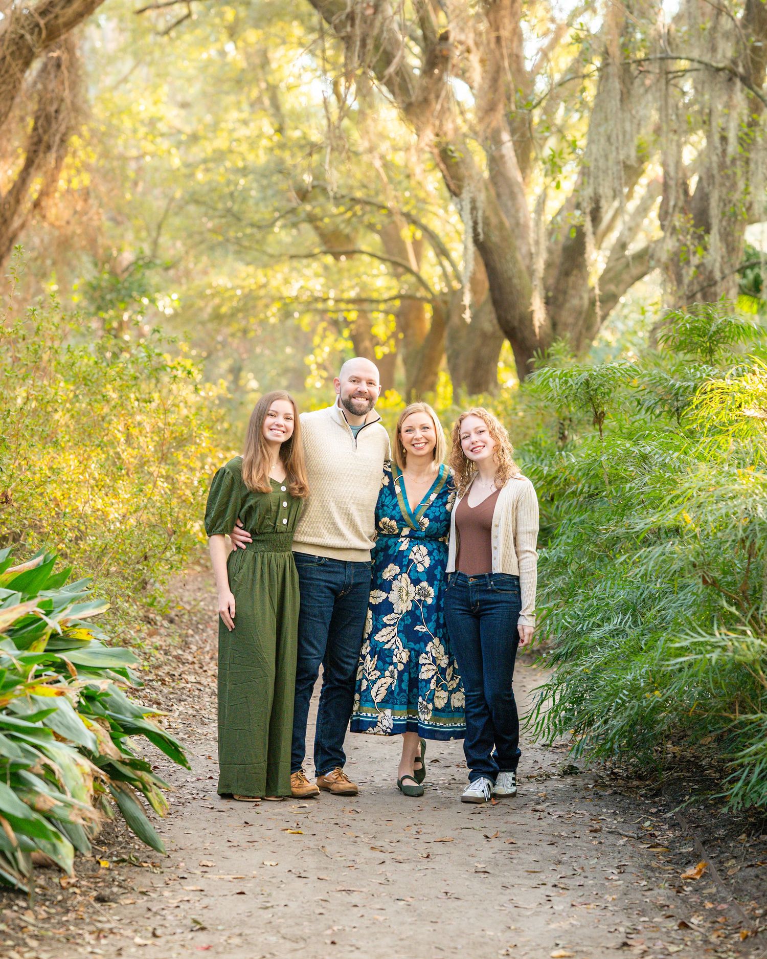 Group portrait on nature path with lush greenery and golden sunlight filtering through trees.
