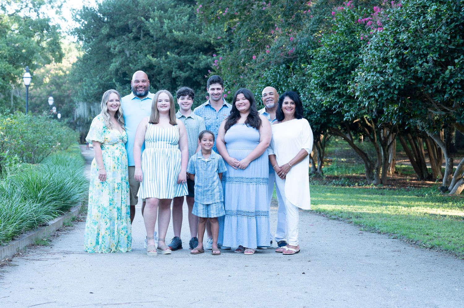 Unedited Photo: A group in coordinated blue and white outfits poses together outdoors in a natural setting.