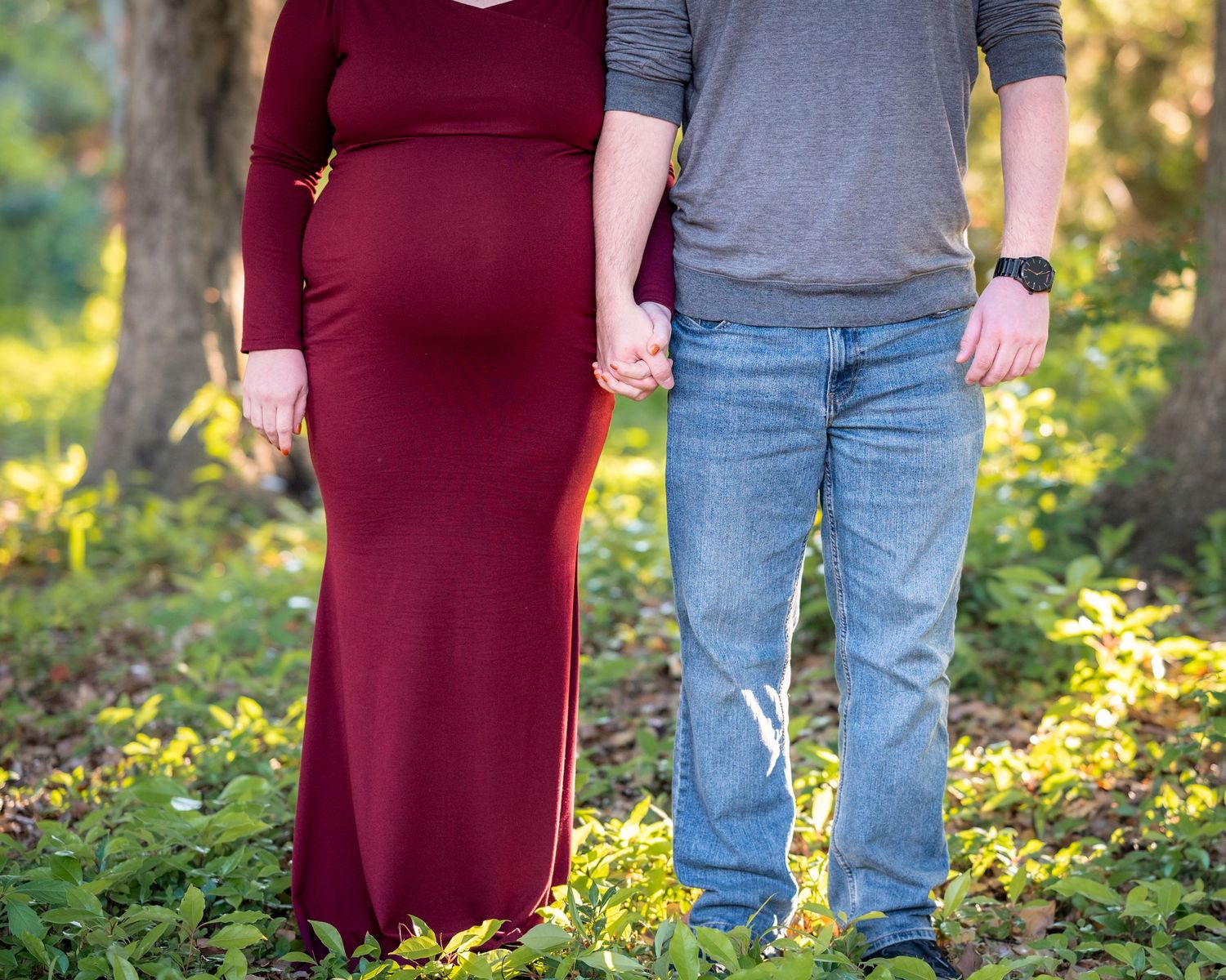 A close-up shot showing a couple standing together in casual attire against a natural backdrop.