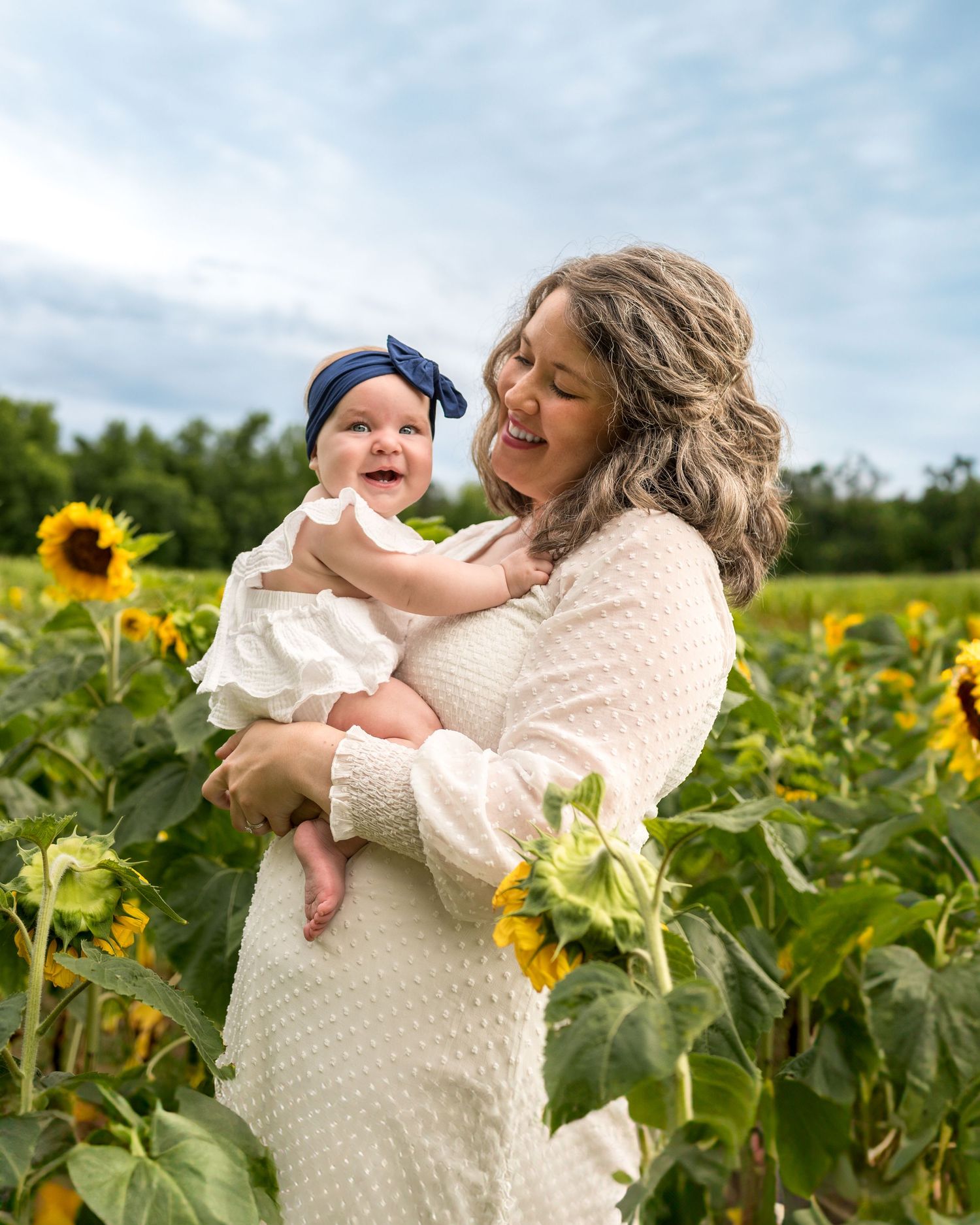 Mother and child sharing loving moments in a vibrant sunflower field.