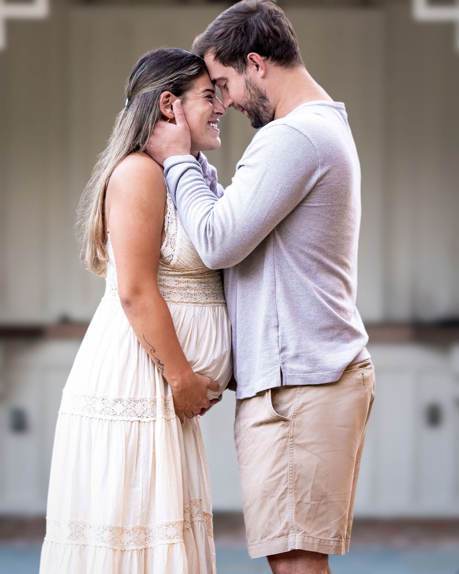 A tender moment between a couple in light colored clothing sharing an intimate embrace.