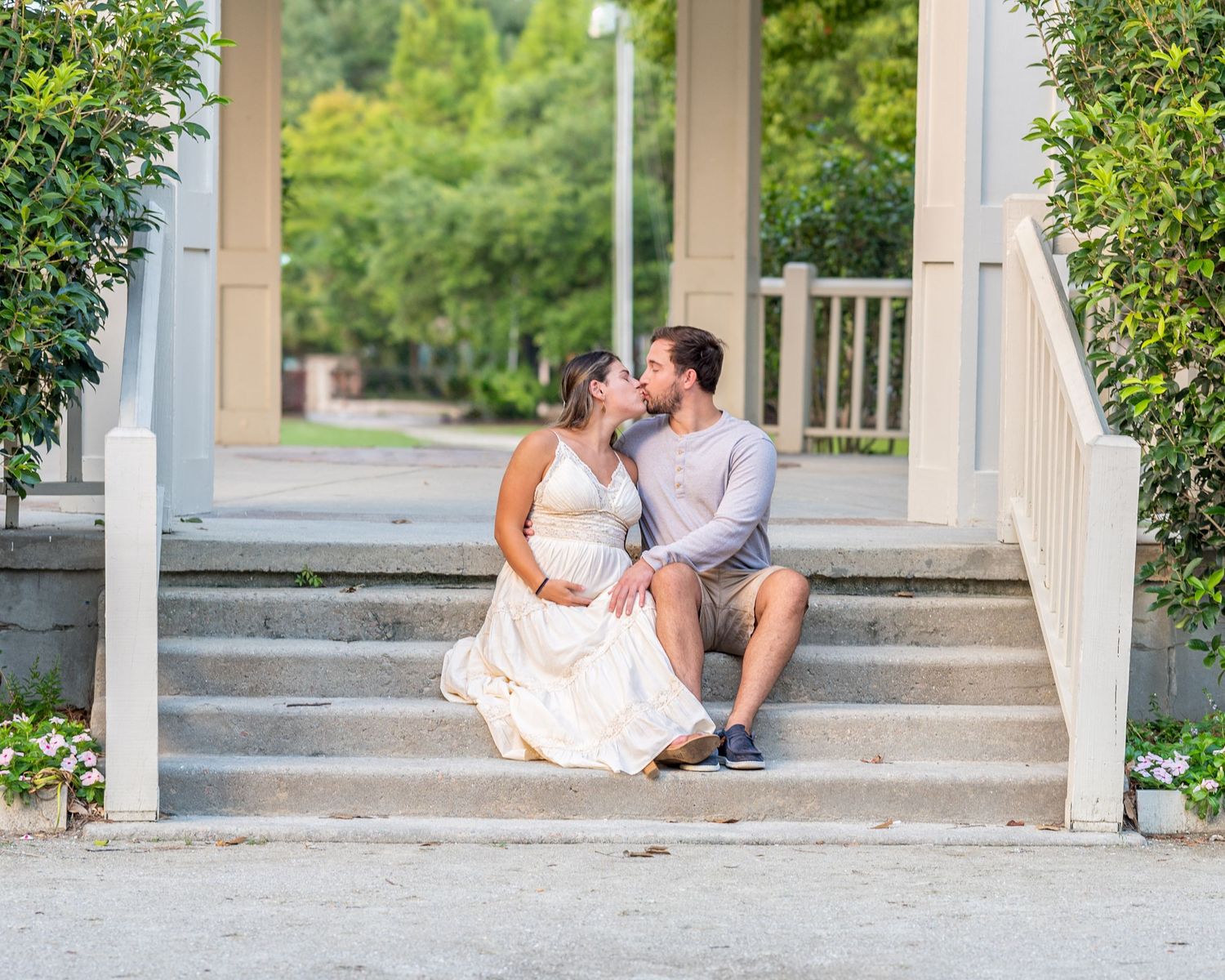 A tender moment shared on white porch steps surrounded by greenery.