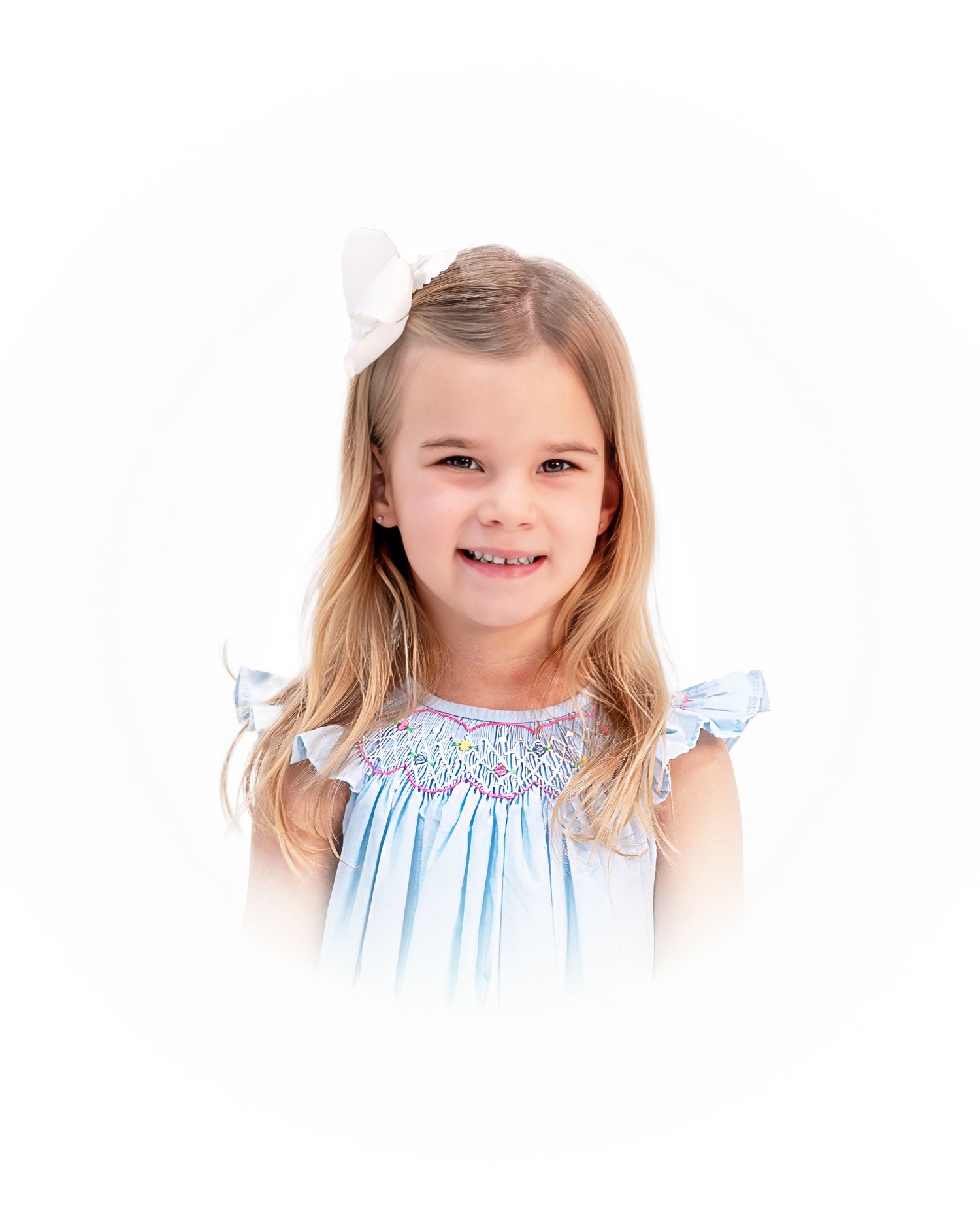 Child wearing blue smocked dress with flutter sleeves smiling against white background during her heirloom portrait session