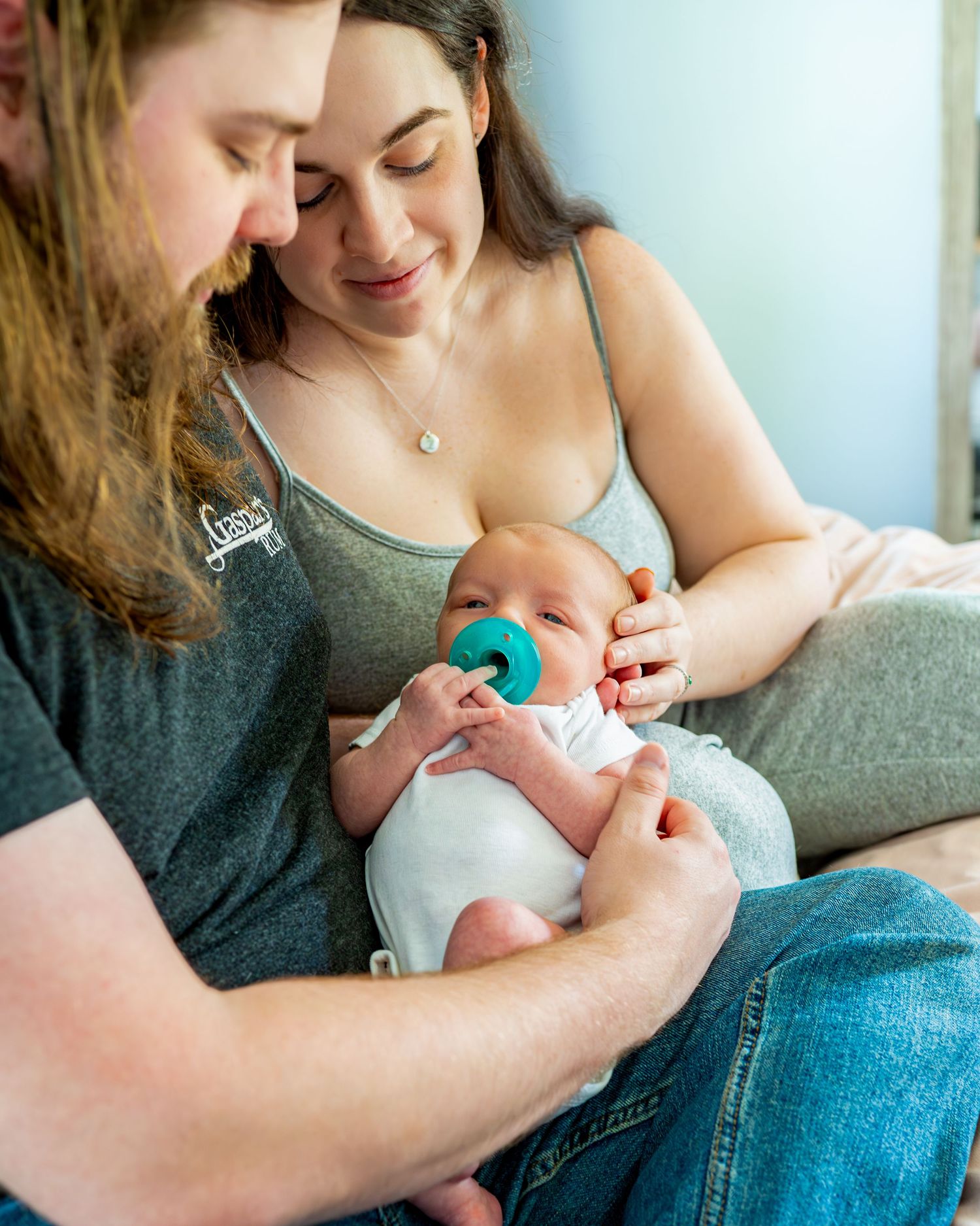 A tender moment as parents gaze at their newborn during their lifestyle newborn session.