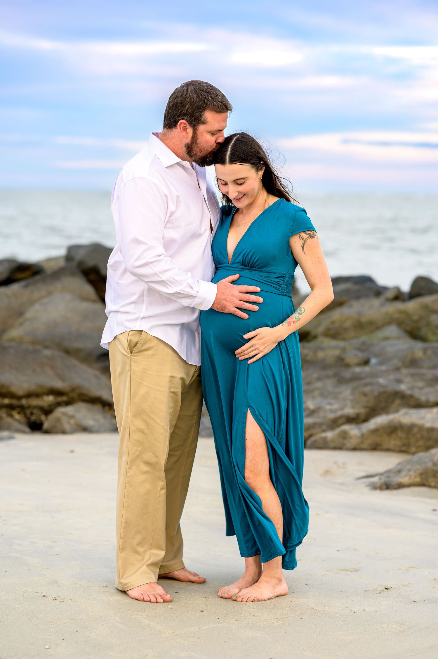 A tender moment shared on a rocky beach with ocean views.