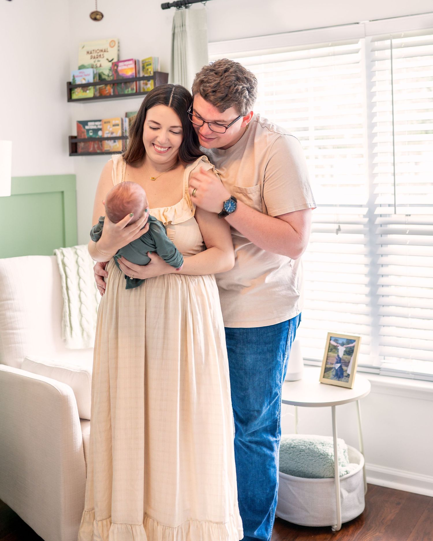 Loving couple embracing in bright nursery room with white decor.