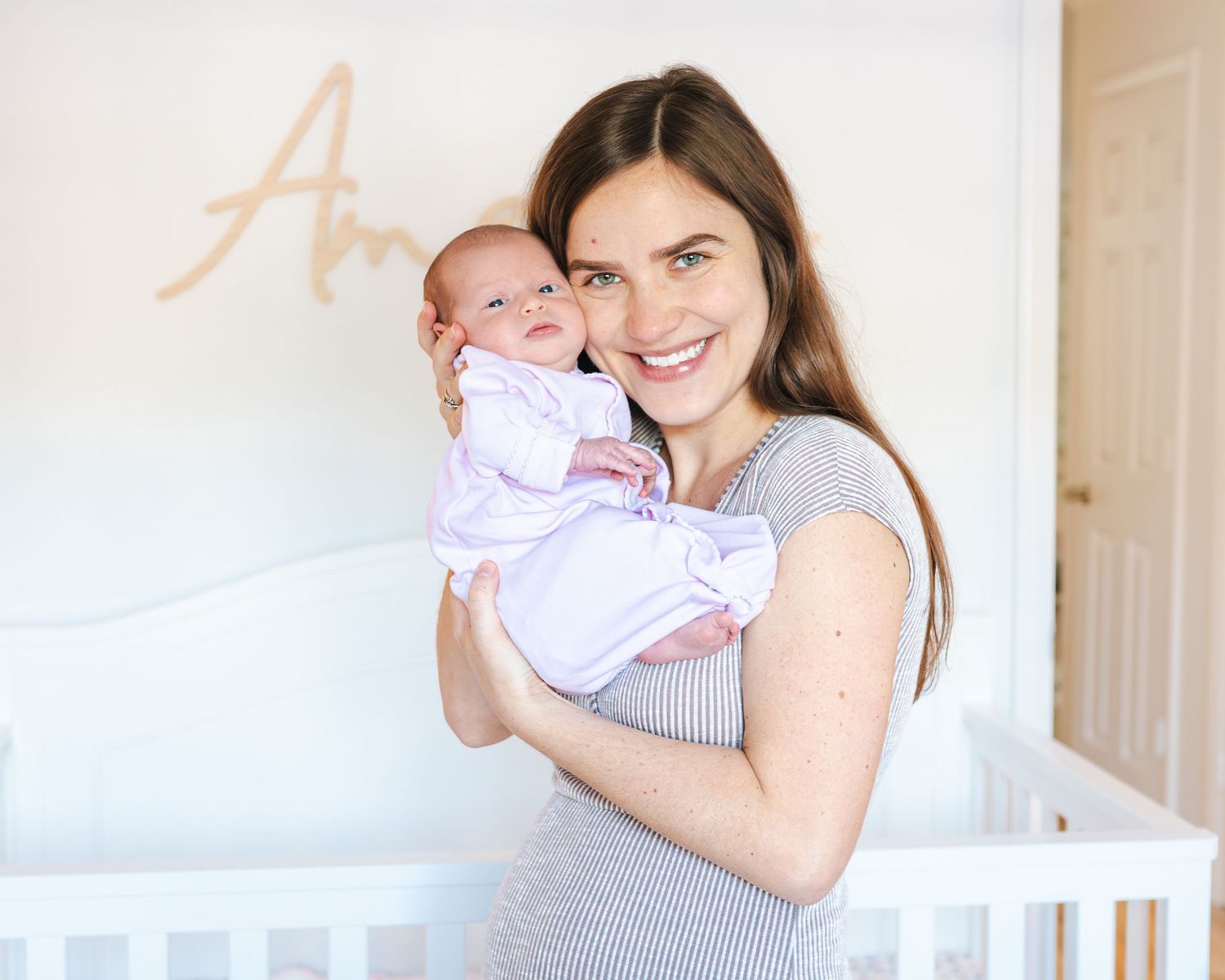 Katrina holds her newborn daughter to her face.