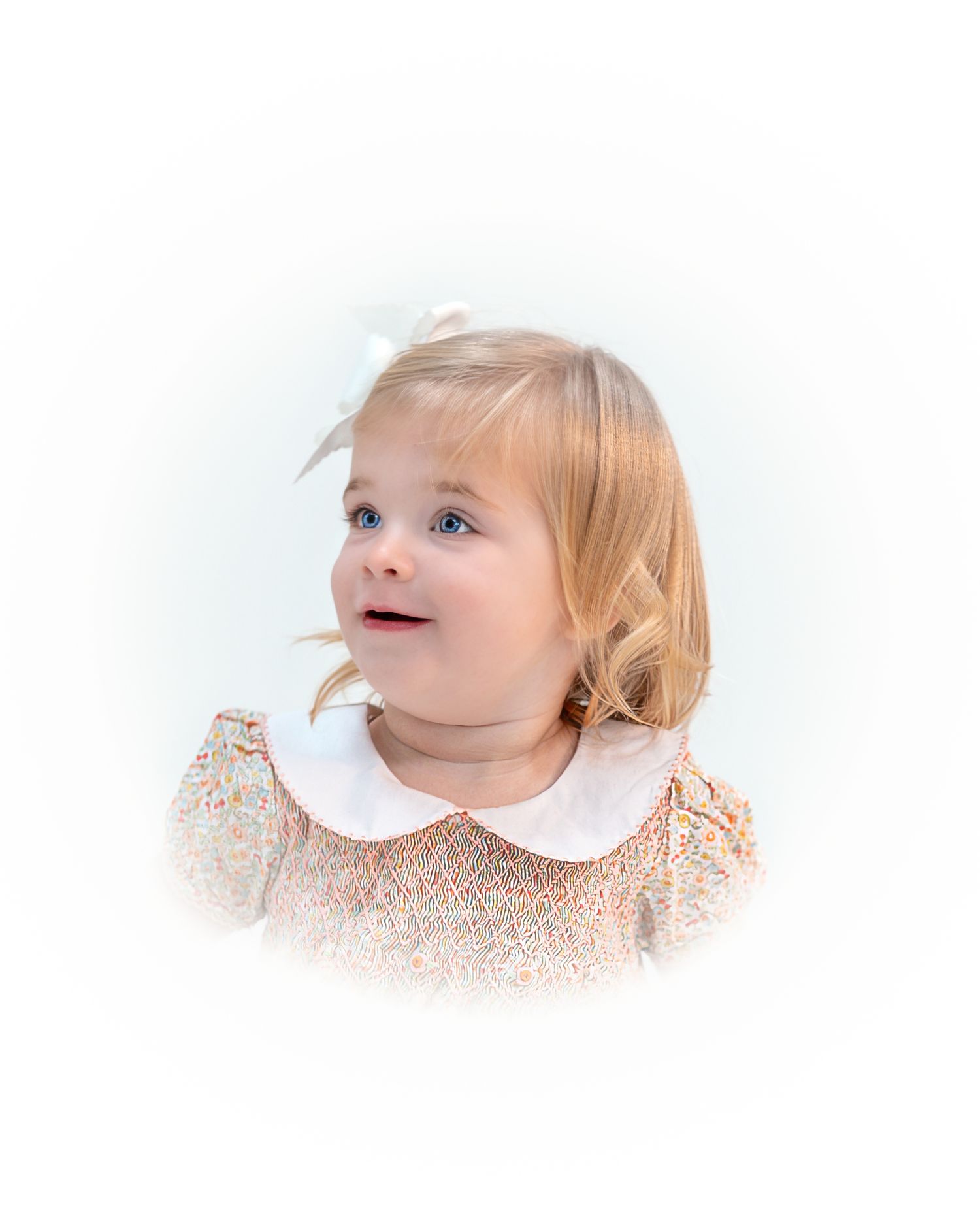 Sweet toddler in a peach floral dress with white peter pan collar gazes upward during her heirloom portrait session