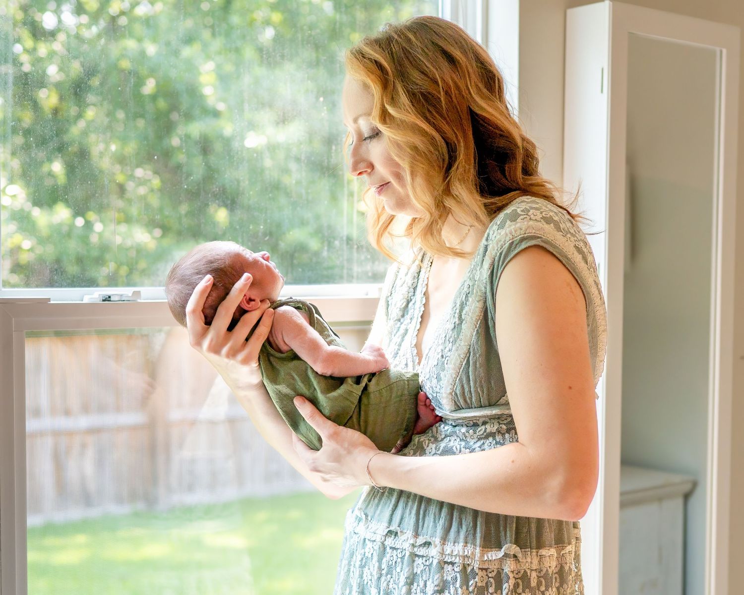 Family lifestyle photography session by a bright window with white wainscoting.