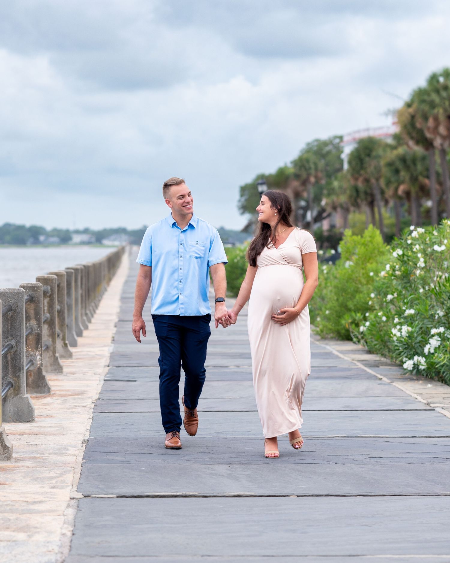 Husband and Pregnant wife walk along battery of Charleston SC
