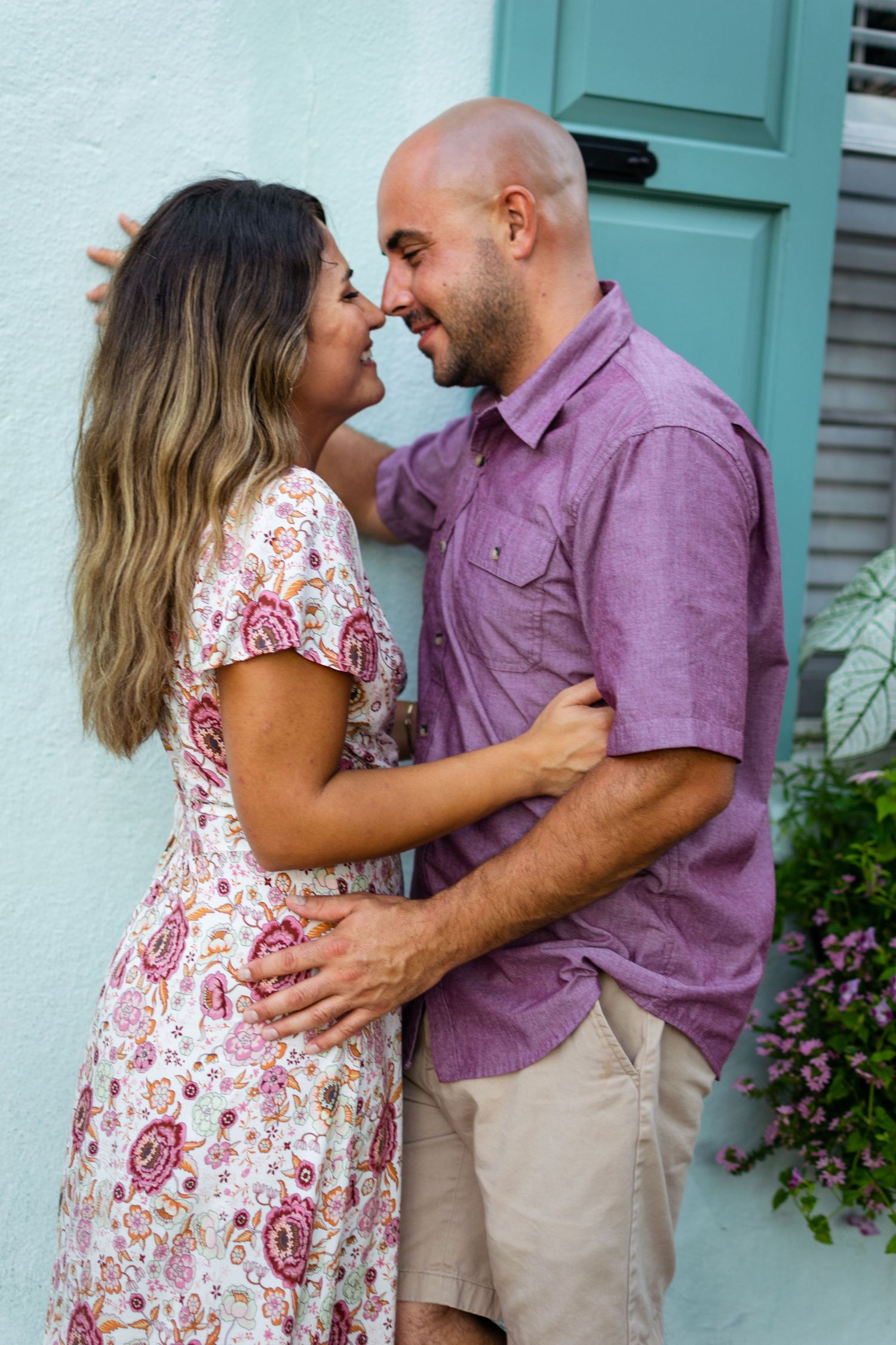 A couple stands embraced and laughing in downtown Charleston during their couple's photography session.
