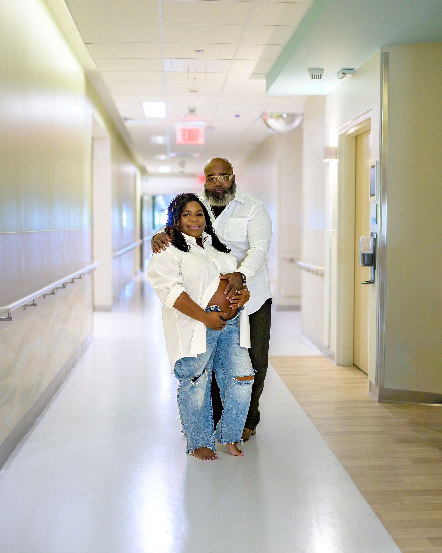 Ellen and her husband pose in the hospital hallway during their maternity session while on bedrest.