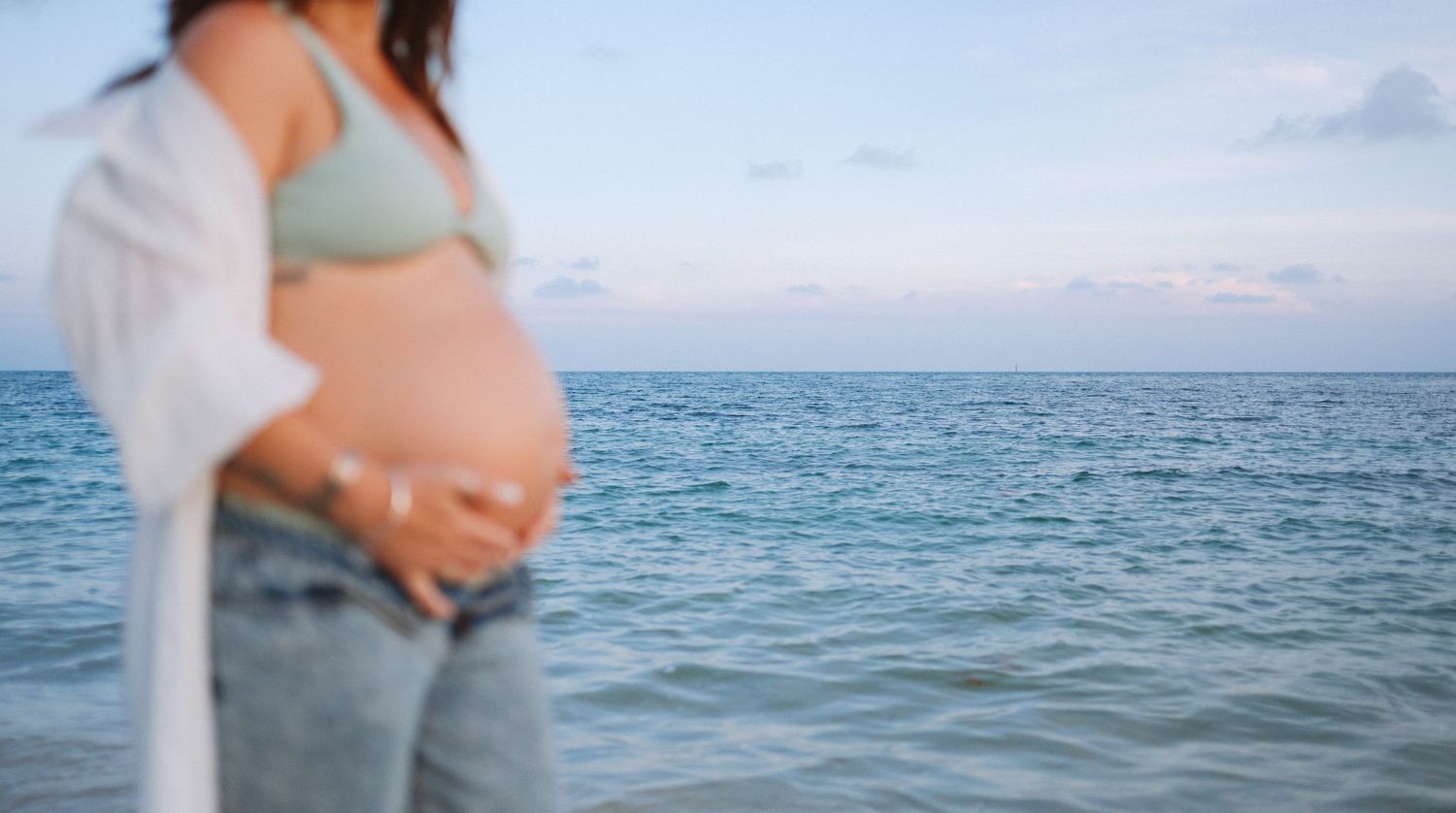Key West maternity photographer capturing sunset pregnancy portraits with warm golden light and ocean backdrop