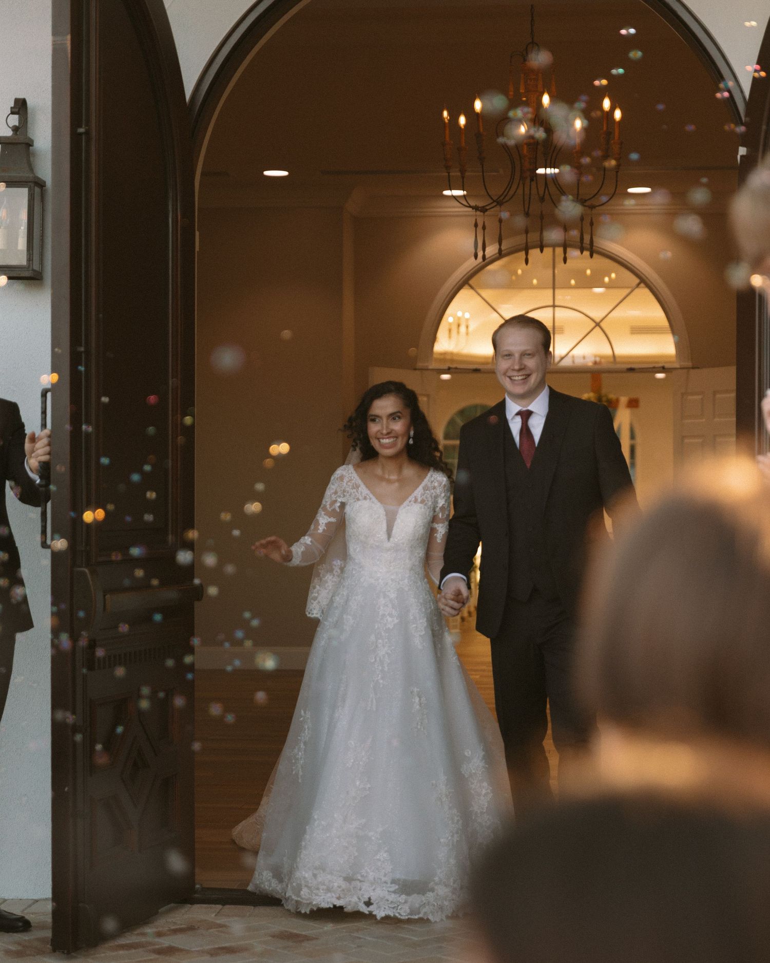 Newlyweds share their first kiss during the ceremony exit, surrounded by cheering guests.
