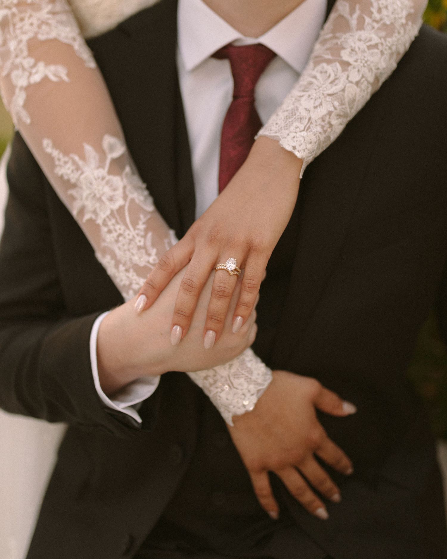 Bride and groom embrace in front of the venue, a timeless portrait with soft, natural tones.