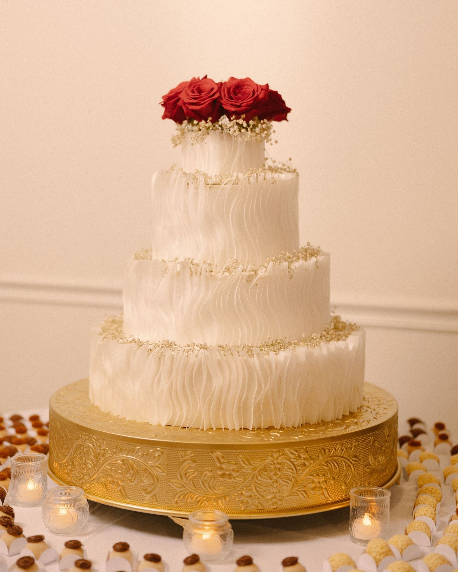 Elegant tiered wedding cake with soft detailing and floral accents, styled for the reception.
