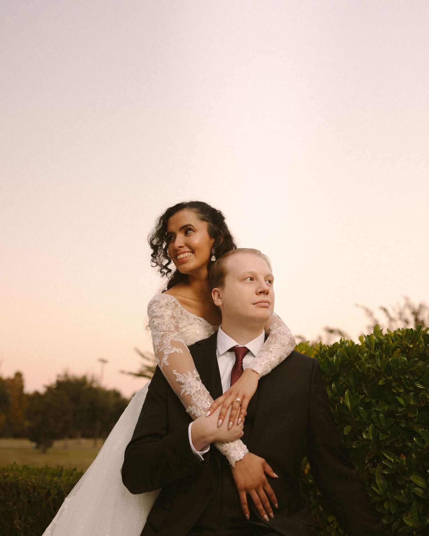 Bride and groom embrace in front of the venue, a timeless portrait with soft, natural tones.